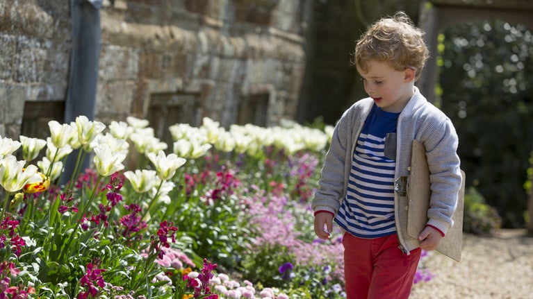 Child with clipboard in the garden at Canons Ashby, Northamptonshire